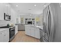 Bright kitchen featuring white cabinetry, stainless steel appliances and an island with a sink at 11222 Rapallo Ln, Windermere, FL 34786