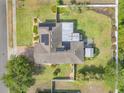 Aerial view of the house showing the roof with solar panels, back yard, and surrounding landscaping at 115 Los Arbor Dr, Deland, FL 32724
