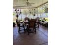 Screened-in patio features a ceiling fan and comfortable seating, ideal for outdoor dining and relaxation at 115 Los Arbor Dr, Deland, FL 32724