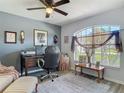 Well-lit office with a ceiling fan, desk, decorative accents, and a large window at 1156 Rivercrest Ct, Port Orange, FL 32128
