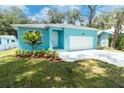 Charming turquoise home with a well-manicured lawn and attached one car garage at 1209 Palmetto St, New Smyrna Beach, FL 32168