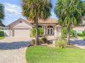 Charming single-story home boasting an attached two-car garage, lush landscaping, and a brick paver driveway at 133 Via Capri, New Smyrna Beach, FL 32169