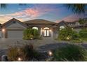 Beautiful home at dusk featuring a brick driveway and professionally landscaped front yard with landscape lighting at 133 Via Capri, New Smyrna Beach, FL 32169