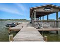 Private boat dock featuring a covered slip, boat lift, and wooden walkway at 1601 S Riverside Dr, Edgewater, FL 32132