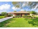 Lovely single-story brick home featuring a carport, well-maintained lawn, and lush landscaping at 1688 Town Park Dr, Port Orange, FL 32129