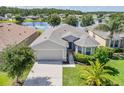 Beautiful aerial view of a single-story home, lush green lawn, and tranquil lake backdrop at 1748 Savannah Ln, Port Orange, FL 32128