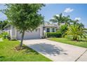 Landscaped front yard featuring mature tree, grass, and inviting curb appeal at 1748 Savannah Ln, Port Orange, FL 32128