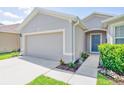 Close up of a single-story home with a two-car garage and beautifully landscaped walkway at 1748 Savannah Ln, Port Orange, FL 32128