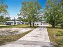This long, private driveway leads to a well-maintained, single-story home with mature trees at 1812 Bayview Dr, New Smyrna Beach, FL 32168