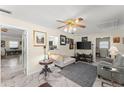 Bright Gathering room features marble flooring, a ceiling fan, and seamlessly connects to dining and kitchen areas at 1851 Needle Palm Dr, Edgewater, FL 32141