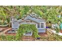 Inviting cottage-style home with lush greenery over the entry and a cozy porch area at 209 Esther St, New Smyrna Beach, FL 32169