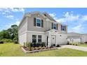 Charming two-story home featuring blue shutters, a manicured lawn, and a two-car garage at 2516 Hoptree Ln, Edgewater, FL 32141