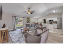 Comfortable living room featuring gray sofas, a ceiling fan, and sliding glass doors leading to the backyard at 2713 Needle Palm Dr, Edgewater, FL 32141