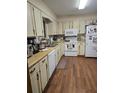 Functional kitchen with white appliances, wood cabinets, and ample countertop space for meal preparation at 2725 Travelers Palm Dr, Edgewater, FL 32141