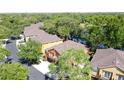 Aerial view showcasing orange and yellow two-story homes nestled within a lush, green, lakeside community at 3311 Pine Oak Trl, Sanford, FL 32773