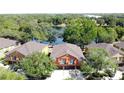 Aerial shot of a home featuring an orange exterior, two-car garage, and close proximity to a serene lake at 3311 Pine Oak Trl, Sanford, FL 32773