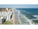 An aerial view of a beachfront condo, sandy beach, and Atlantic ocean at 4151 S Atlantic Ave # 414, New Smyrna Beach, FL 32169
