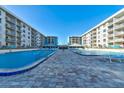 Beautiful pool area with lounge chairs and tables for residents enjoyment at 4151 S Atlantic Ave # 414, New Smyrna Beach, FL 32169