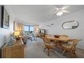 Inviting living room with a ceiling fan, coastal decor, dining area and ocean views at 4201 S Atlantic Ave # 402, New Smyrna Beach, FL 32169