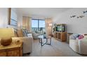 Bright living room boasts comfortable seating, coastal decor, and access to the balcony with ocean views at 4201 S Atlantic Ave # 402, New Smyrna Beach, FL 32169