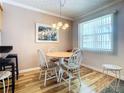 Cozy dining area with a wood table, four chairs, and natural light from a window at 4225 S Atlantic Ave # 218, New Smyrna Beach, FL 32169