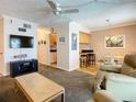 Relaxing living room featuring a TV, ceiling fan, and view into dining area at 4225 S Atlantic Ave # 218, New Smyrna Beach, FL 32169
