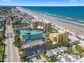 Aerial view of beachfront condos, a parking lot, and the stunning beach and ocean at 425 S Atlantic Ave # 302, New Smyrna Beach, FL 32169