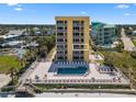 Bright yellow condo building with a pool deck, ocean views, and a beach just steps away at 425 S Atlantic Ave # 302, New Smyrna Beach, FL 32169