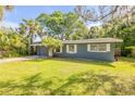 Ranch style home with lush green yard and tropical landscaping at 431 Palmetto St, Edgewater, FL 32132