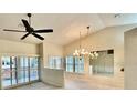 Bright living room with vaulted ceilings, fan, chandelier and sliding glass doors at 439 Bouchelle Dr # 202, New Smyrna Beach, FL 32169