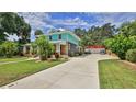 Exterior view showing the well-manicured lawn, driveway, garage, and landscaping around the house at 508 Faulkner St, New Smyrna Beach, FL 32168