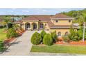 Beautiful front view of this tan single-Gathering home with a brown roof and manicured lawn at 610 Mura Ct, New Smyrna Beach, FL 32168
