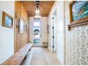 Stylish entryway featuring wooden accents, patterned wallpaper, a long bench, and unique overhead lighting at 6542 Rover Way, St Cloud, FL 34771
