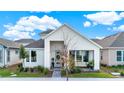 Inviting home exterior with covered porch, stylish landscaping, and a light blue front door under a cloudy sky at 6542 Rover Way, St Cloud, FL 34771
