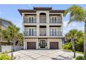 Elegant three-story home with multiple balconies and a modern two car garage at 6771 Turtlemound Rd, New Smyrna Beach, FL 32169