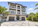 Charming three-story home featuring multiple balconies and a beautifully paved driveway at 6771 Turtlemound Rd, New Smyrna Beach, FL 32169