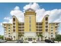 Beautiful yellow condo building with balconies, palm trees, and a well-maintained parking area under a partially cloudy sky at 7 Riverwalk Dr # 205, New Smyrna Beach, FL 32169