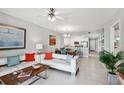 Bright living room features modern white furniture, tiled floors, an adjacent dining area and open kitchen design at 7 Riverwalk Dr # 205, New Smyrna Beach, FL 32169
