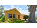 Side view of a yellow single-story home showcasing well-kept landscaping and an attached two-car garage at 706 Sky Tree Ct, New Smyrna Beach, FL 32168