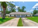 Inviting home with a well-manicured front lawn, long driveway, attached garages, and a neatly kept landscape at 115 Bob White Ct, Daytona Beach, FL 32119