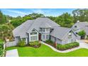 Charming two-story home with gray roof, manicured lawn and a welcoming red front door at 128 Godfrey Rd, Edgewater, FL 32141