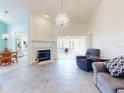 Bright living room with a fireplace, elegant chandelier, and neutral tile flooring throughout at 1307 Wayne Ave, New Smyrna Beach, FL 32168