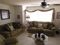 Cozy living room with tiled floor, ceiling fan, and two couches with decorative pillows at 1627 Umbrella Tree Dr, Edgewater, FL 32132