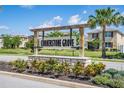 Cornerstone Grove community sign featuring stone base, wooden pergola, professional landscaping, and palm tree at 1674 Coulter Ln, Port Orange, FL 32129