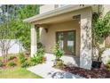 Charming front porch featuring a double-door entry, manicured landscaping, and natural light, enhancing curb appeal at 1674 Coulter Ln, Port Orange, FL 32129