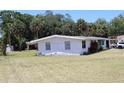 Ranch-style home with a large lawn, and mature trees offering shade at 1830 Needle Palm Dr, Edgewater, FL 32132