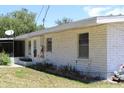 Rear exterior view of home showcasing the brick architecture and garden beds at 1830 Needle Palm Dr, Edgewater, FL 32132