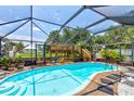 Screened-in pool area with a view of the backyard and surrounding greenery, perfect for relaxation and recreation at 184 Azalea Rd, Edgewater, FL 32141
