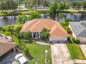 Beautiful waterfront home featuring lush landscaping, well-maintained lawn, and a private driveway at 1840 Tara Marie Ln, Port Orange, FL 32128