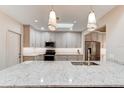 Gourmet kitchen featuring stainless steel appliances, pendant lights, granite countertops, and an island with a sink at 1903 Sprucewood Way, Port Orange, FL 32128